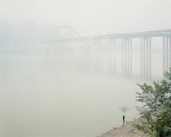 Fisherman in the mist at Cayiuanba Changjiang Bridge. Yuzhong District. Chongqing. China. December 2017

Chongqing is almost permanently covered in a thick mist, a mix of damp and pollution, which makes it one of the least sunny cities in the country. Along the banks of the Yangtze, which are still wild in many places, fishermen go about their business despite highly polluted water.